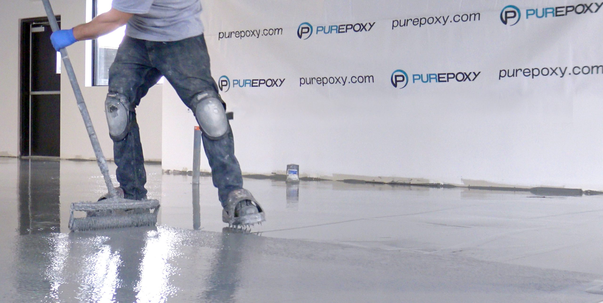 man spreading epoxy on the floor - medium